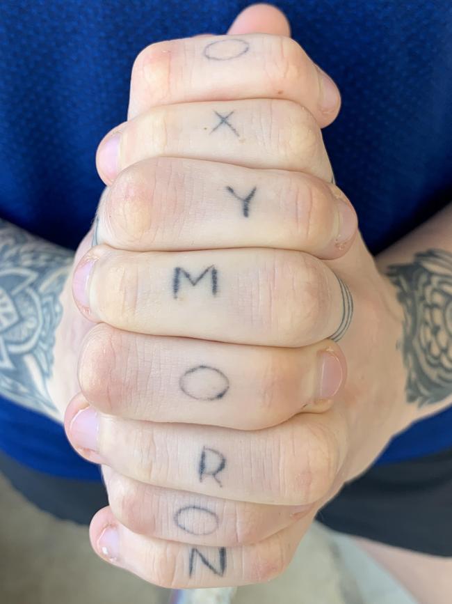 Harris’s new tattoo, which spells “oxymoron” on her fingers.