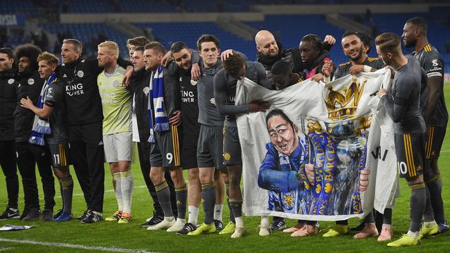 Leicester City players and staff hold a banner showing chairman Vichai Srivaddhanaprabha holding the Premier League trophy. Picture: AFP
