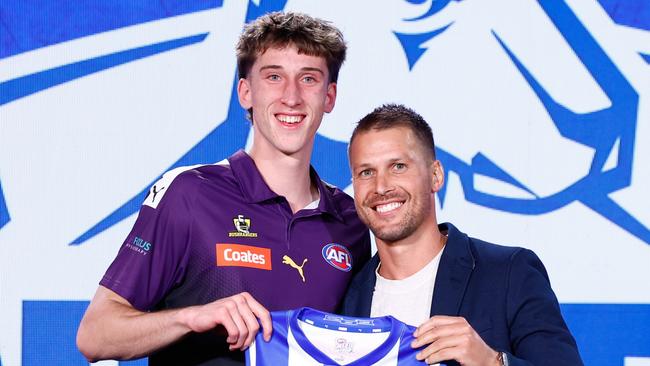 MELBOURNE, AUSTRALIA - NOVEMBER 20: The number 27 pick, Matt Whitlock is presented his North Melbourne Kangaroos jumper by Andrew Swallow during the 2024 Telstra AFL Draft at Marvel Stadium on November 20, 2024 in Melbourne, Australia. (Photo by Michael Willson/AFL Photos via Getty Images)