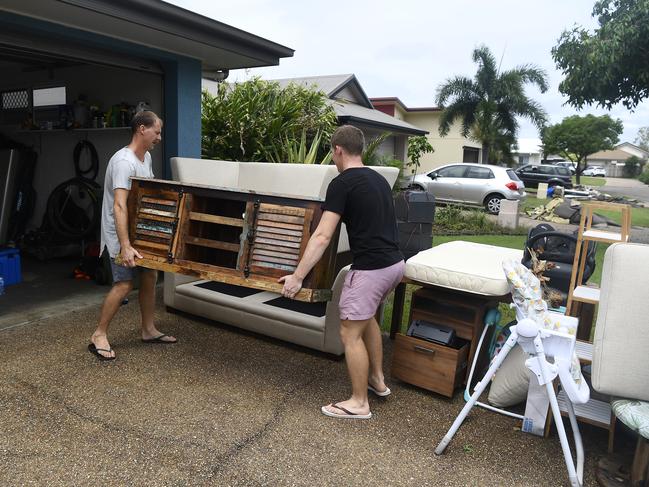 Townsville residents Nathan Graham and Sean Graham dump flood damaged furniture outside their home in the suburb of Idalia in Townsville, Australia. Picture: Getty