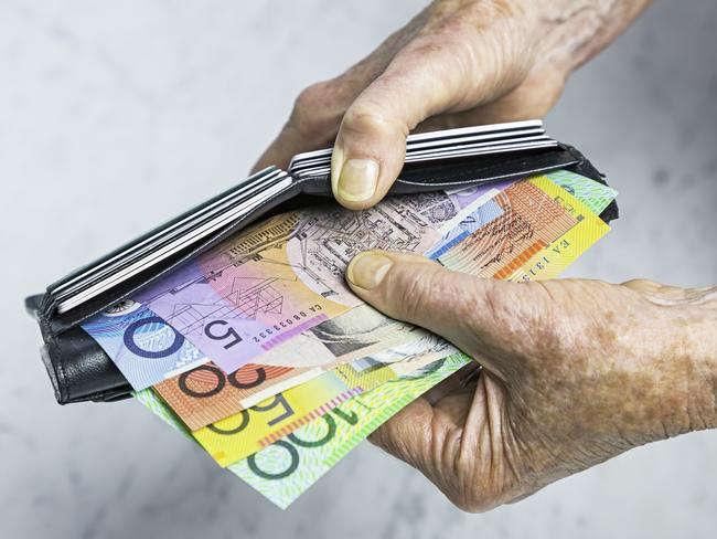 Payment. Close-up, senior female hands taking Australian banknotes (cash, currency) from purse containing many credit cards. Horizontal, studio, copy space, spread notes.