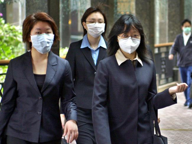 Office workers in Hong Kong wearing masks in attempt to prevent spread of pneumonia flu disease Severe Acute Respiratory Syndrome "SARS" virus in 2003.