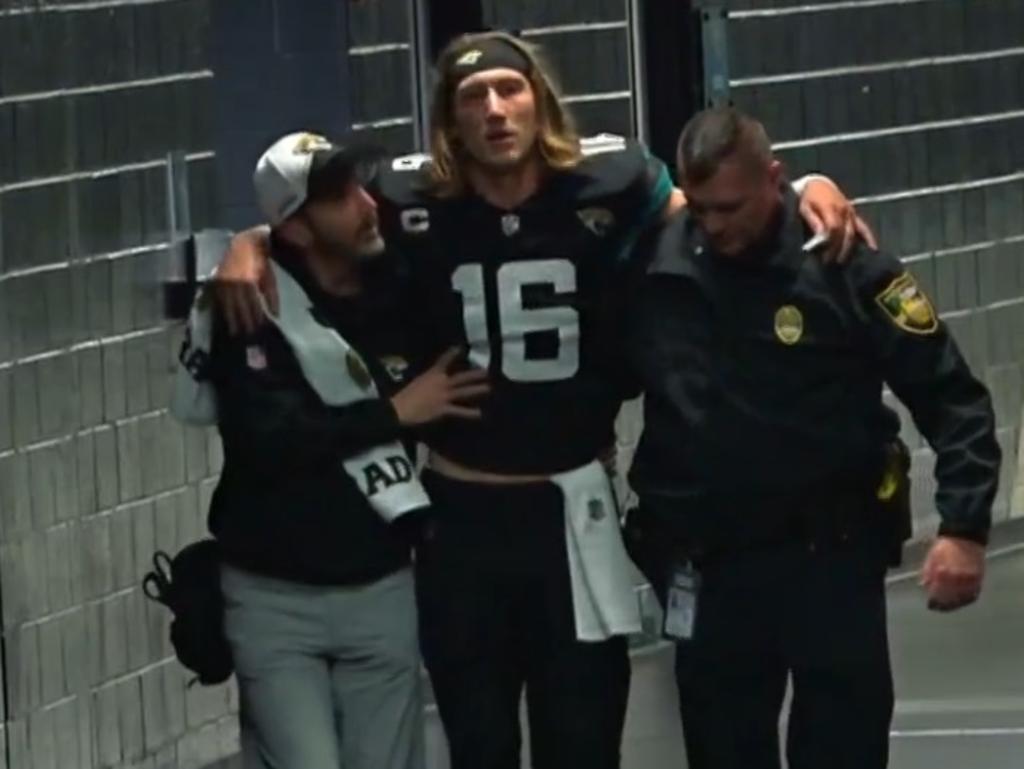 Trevor Lawrence is walked to the locker room after his ankle injury.