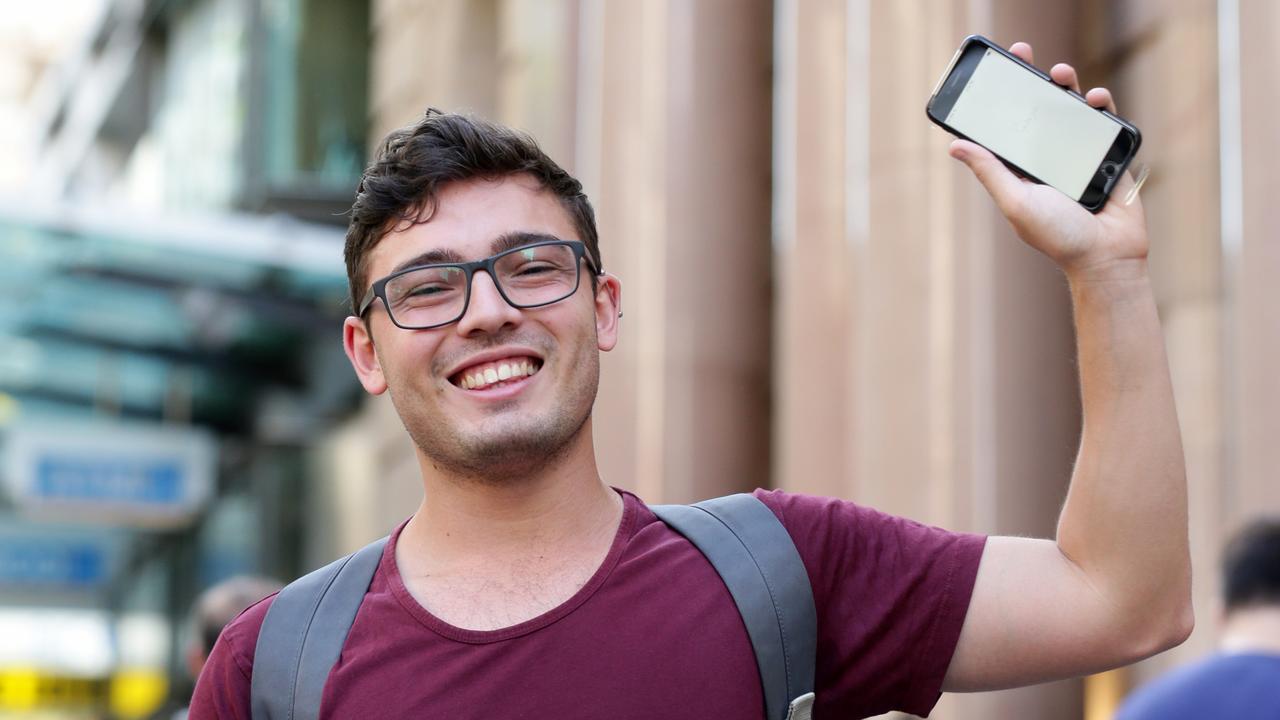 A launch day buyer shows off his new iPhone 7 outside the Apple store in Brisbane. Pic Mark Calleja