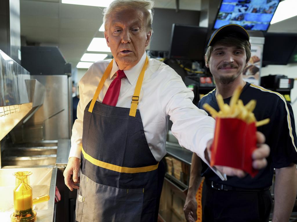 Republican presidential nominee former President Donald Trump hands off an order of fries after working alongside an employee during a visit to McDonald's in Pennsylvania. Picture: Doug Mills/The New York Times via AP