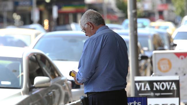 A parking officer issuing a fine on congested Puckle St, Moonee Ponds. Picture: Mark Wilson