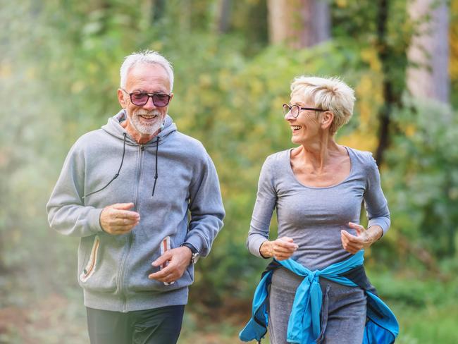 Smiling senior couple jogging in the park. Sports activities for elderly people. Active seniors generic