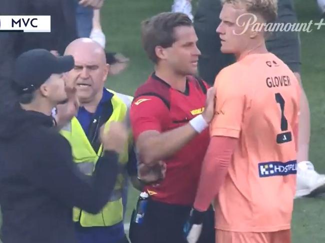 17/12/2022 Tom Glover of Melbourne City is helped by referee Alex  after fans stormed the pitch during the round eight A-League Men's match between Melbourne City and Melbourne Victory at AAMI Park. Picture:  Fox Sport