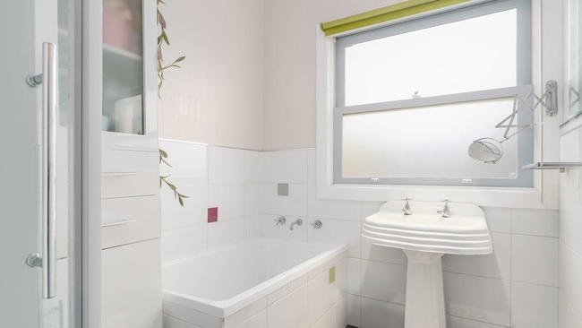 White tiles and a glass shower screen add a modern edge to the bathroom.