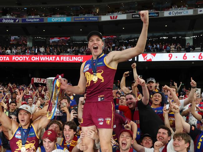 Lions players celebrates with fans after Brisbane win the AFL Grand Final, defeating the Sydney Swans at the MCG. Picture Lachie Millard