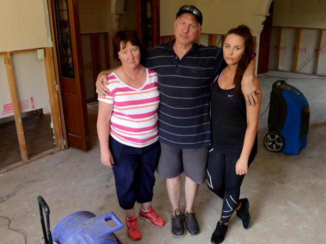 Linton Schiller with his wife Jenny and daughter Lauren, in what’s left of their lounge room after their house in Paradise was flooded by a burst mains pipe last week. Pic: Tricia Watkinson