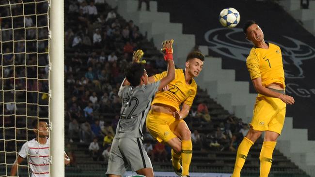 Australia's Joseph Champness heads a goal against Cambodia in Phnom Penh last week. Pic: AFP