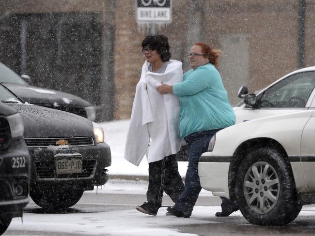 Taken to safety ... A civilian is escorted after reports of a shooting near the clinic. Picture: Andy Cross/The Denver Post.