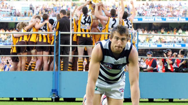 Corey Enright struggles to get up off the ground as Hawthorn receives the premiership cup.