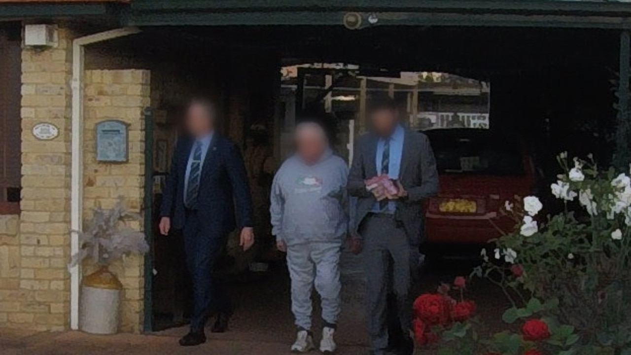 Mr Caine is led out of a home after being arrested by police. Picture: NSW Police