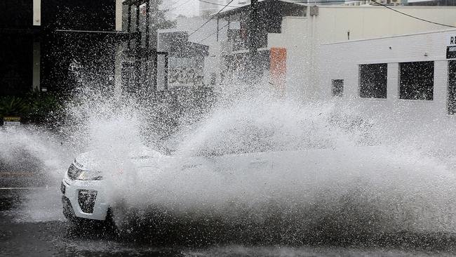 A car hits water as intense rain falls on Brisbane on Saturday afternoon. Picture: David Clark