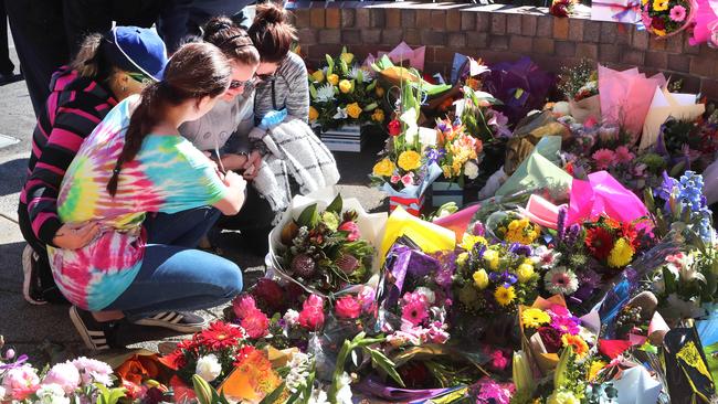 Susan Forte, wife of murdered policeman Senior Constable Brett Forte visits the memorial to her husband outside Toowoomba Police Station with her family. Picture: Darren England.