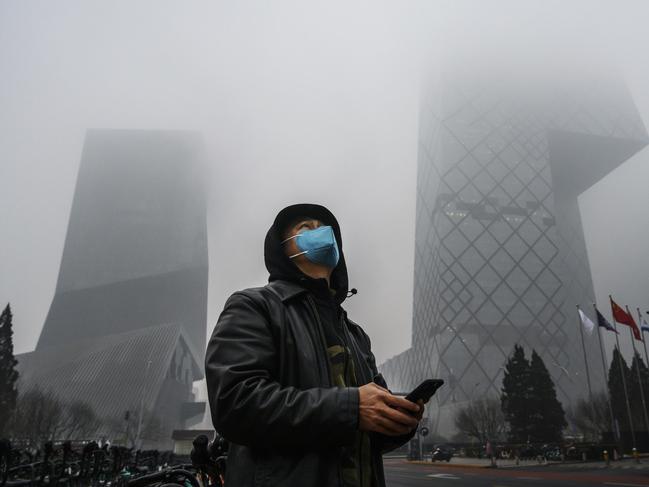 BEIJING, CHINA - FEBRUARY 13: A Chinese man wears a protective mask as he stands near the CCTV building in fog and pollution during rush hour in the central business district on February 13, 2020 in Beijing, China. The number of cases of the deadly new coronavirus COVID-19 rose to more than 52000 in mainland China Thursday, in what the World Health Organization (WHO) has declared a global public health emergency. China continued to lock down the city of Wuhan in an effort to contain the spread of the pneumonia-like disease which medicals experts have confirmed can be passed from human to human. In an unprecedented move, Chinese authorities have maintained and in some cases tightened the travel restrictions on the city which is the epicentre of the virus and also in municipalities in other parts of the country affecting tens of millions of people. The number of those who have died from the virus in China climbed to over 1300 on Thursday, mostly in Hubei province, and cases have been reported in other countries including the United States, Canada, Australia, Japan, South Korea, India, the United Kingdom, Germany, France and several others. The World Health Organization has warned all governments to be on alert and screening has been stepped up at airports around the world. Some countries, including the United States, have put restrictions on Chinese travellers entering and advised their citizens against travel to China. (Photo by Kevin Frayer/Getty Images)