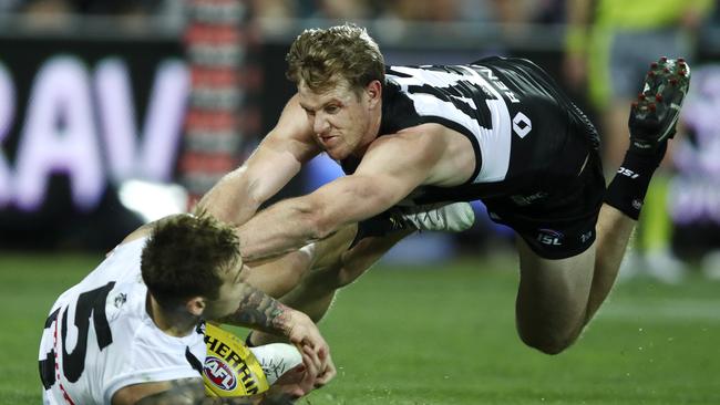 Tom Jonas shows some desperation in defence against Collingwood’s Jamie Elliott. Picture: Sarah Reed