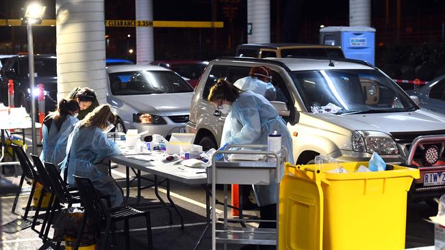 Medical staff work at a drive-through testing site in a shopping centre carpark in Melbourne on June 26, 2020.