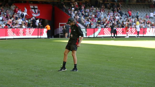 A groundsman flattens divots at Marvel Stadium during Sunday’s Saints-Suns clash. Pic: Michael Klein.