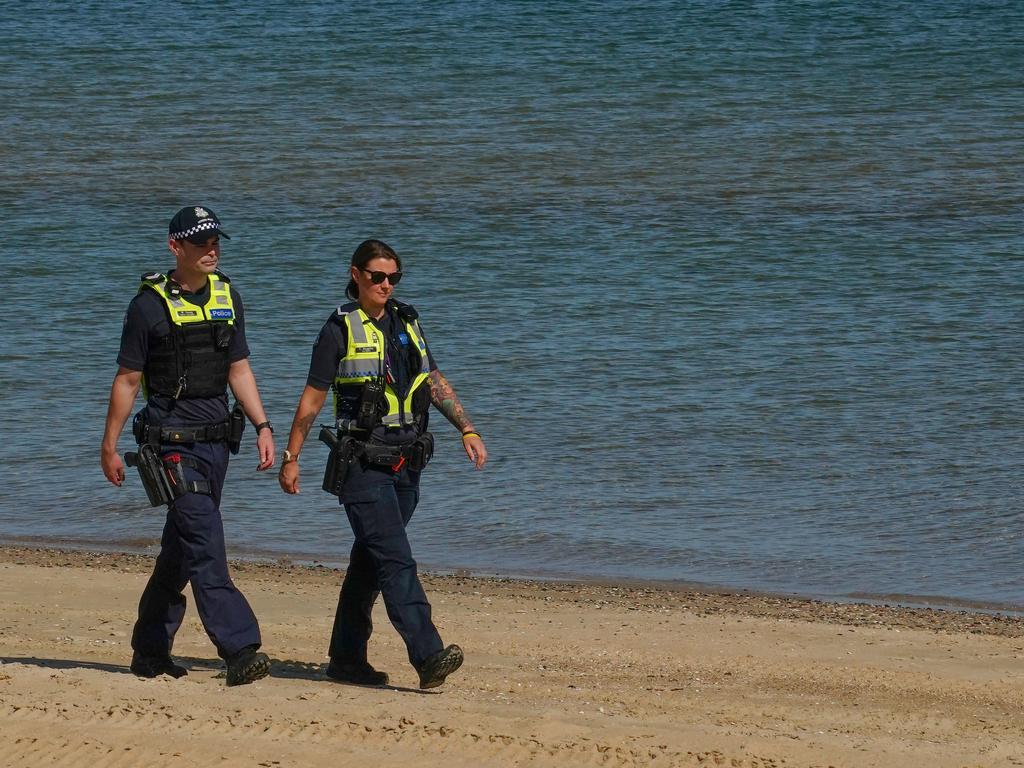 Thinking of a sneaky trip to the beach? Think again. Police officers patrol St Kilda Beach in Melbourne on March 28. Picture: AAP Image/Scott Barbour