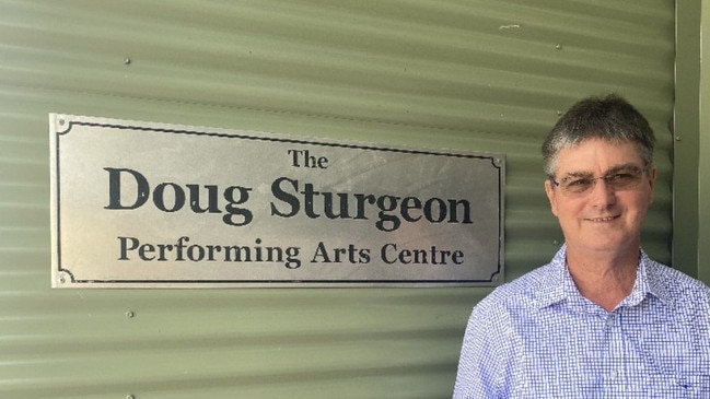 Former Mackay West State School principal and former student Doug Sturgeon next to the sign for the Doug Sturgeon Performing Arts Centre. Photo: Contributed