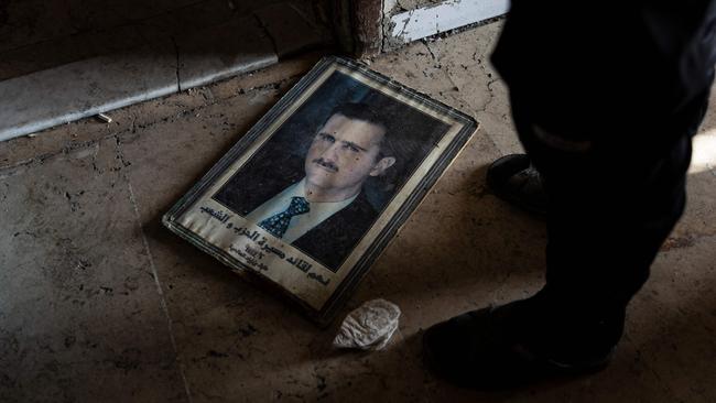 A man stands next to a portrait of toppled Syrian president Bashar al-Assad in the capital Damascus. Picture: AFP