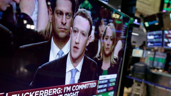 Facebook CEO Mark Zuckerberg appears on a television screen on the floor of the New York Stock Exchange as he testifies in the Senate in Washington, Tuesday, April 10, 2018. (AP Photo/Richard Drew)