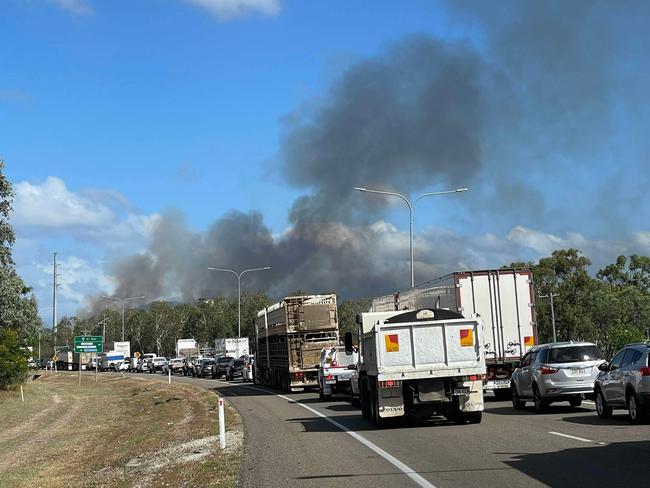 Smoke trails through the air near where the Bruce Highway has been split in two by a fire.