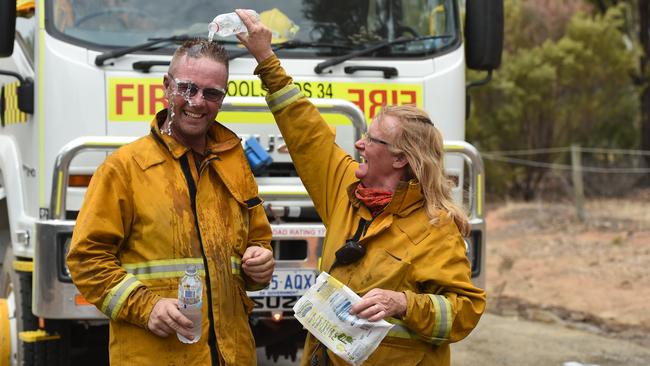 Husband and wife team Marcus and Deb Newlands from Woolsheds CFS cool off after fighting the Angle Vale fire. Picture: Naomi Jellicoe