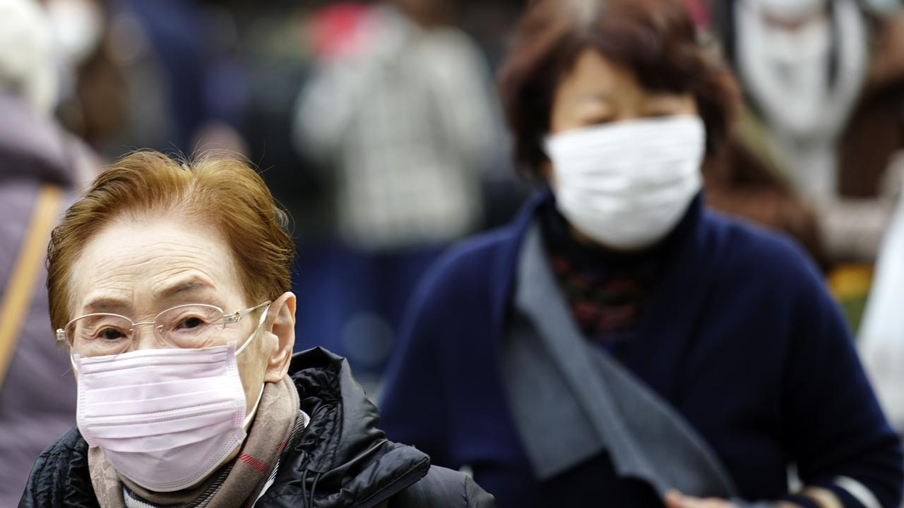 Pedestrian wear protective masks as they walk in a shopping district in Tokyo after a man returning from China tested positive for the new coronavirus linked to SARS. Picture: AP