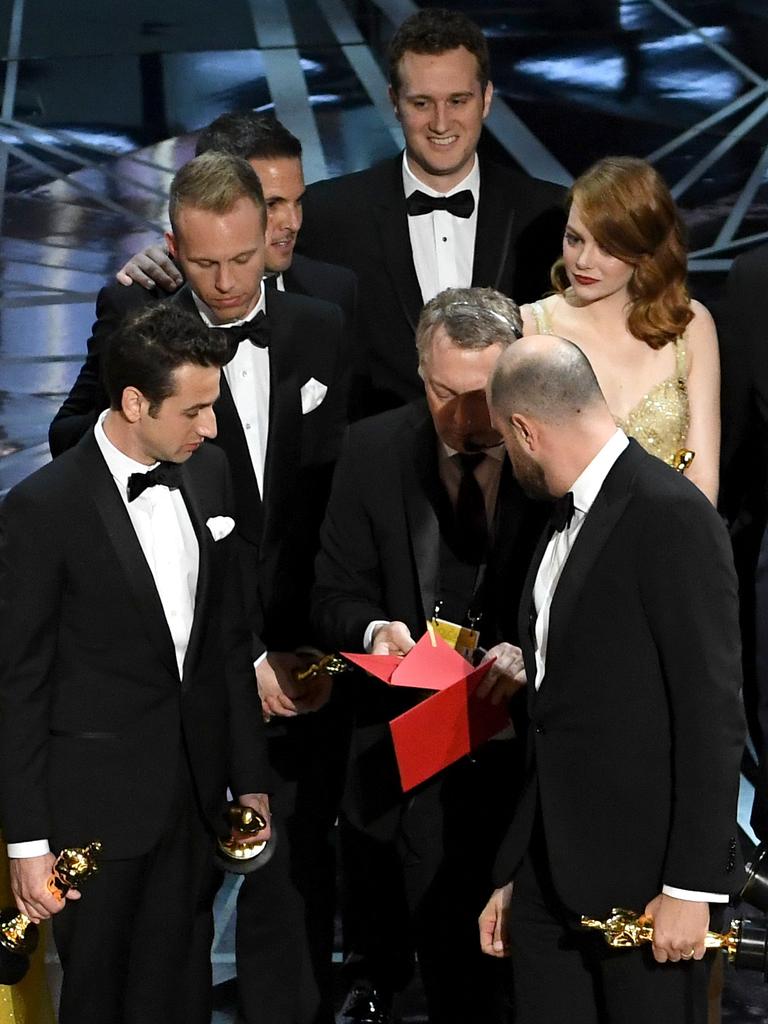 ‘La La Land’ producer Jordan Horowitz consults with production staffer regarding a presentation error of the “Best Picture” award (later awarded to ‘Moonlight’), as composers Justin Hurwitz and actor Emma Stone look on onstage during the 89th Annual Academy Awards. Picture: Getty