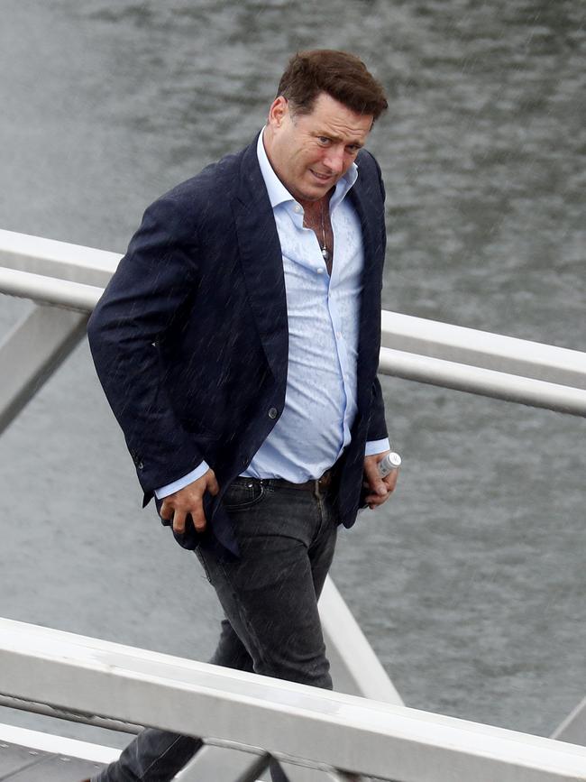 Stefanovic arrives with a bottle of red. The grey skies and drizzle didn’t dampen the day. Picture: News Corp