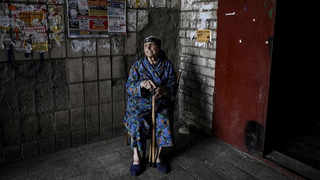 An elderly woman sits at the entrance of an apartment building in the city of Lysychansk. Picture: Aris Messinis/AFP