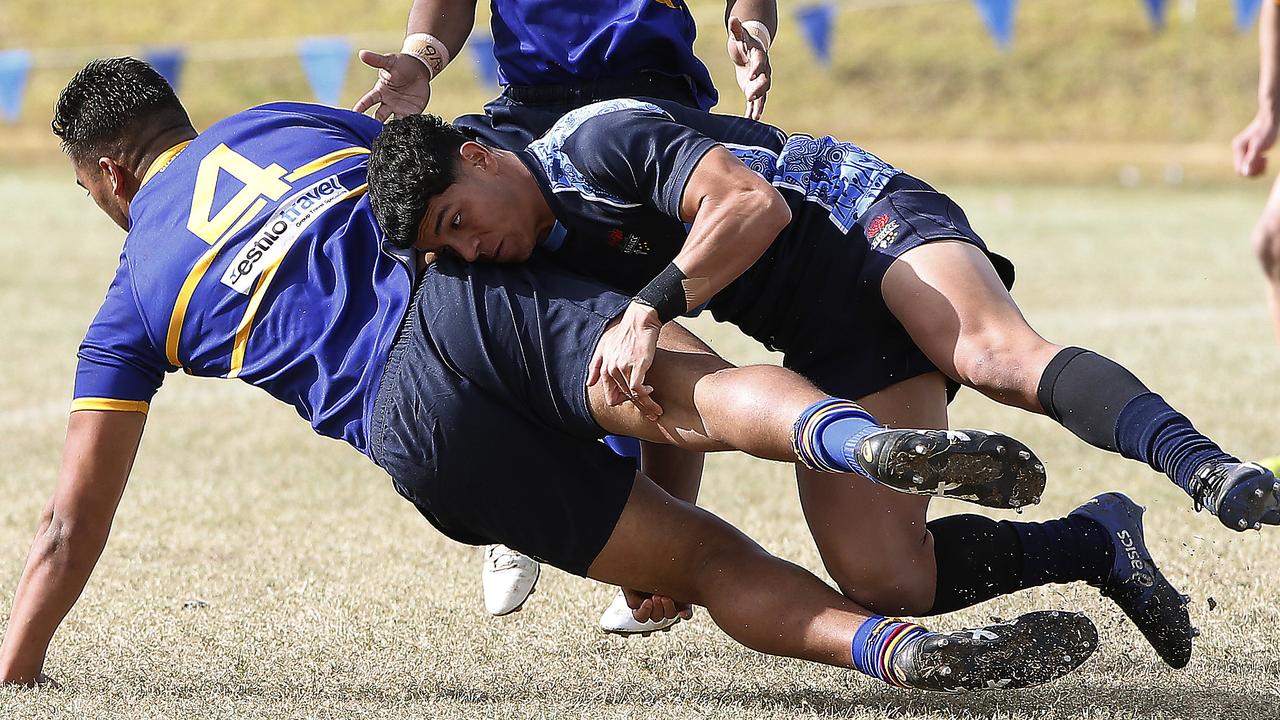 Sydney Junior player Rodney Blake tackled by CCC's Savelio Tamale in a trial match in June.