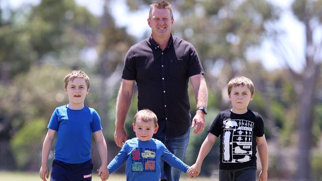 Travis McCarty with twins Cooper and Riley, 7, and little brother Logan, 2, who all suffer from Duchenne muscular dystrophy. Picture: Michael Klein