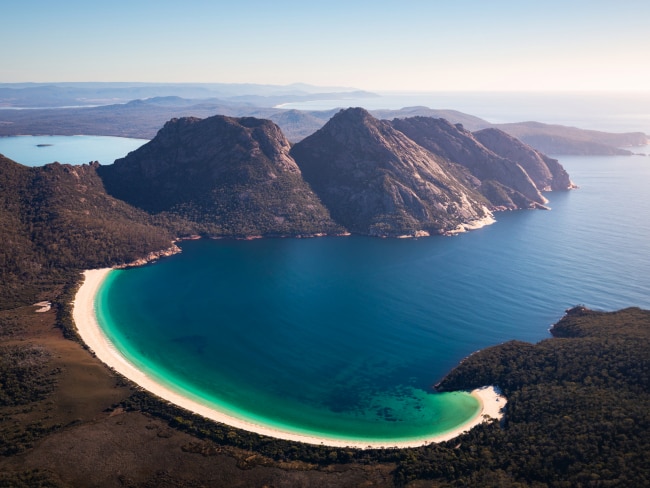 <span>24/50</span><h2>Wineglass Bay, Freycinet National Park, TAS</h2><p>The crescent curve. Its pristine sands. The clear green-blue of the water meeting the surrounding bushland. It’s all of this and so much more that makes Tasmania’s Wineglass Bay one of the world’s best beaches. Lying between Launceston and Hobart, camping nearby and watching the stars above as you drift to sleep is heavenly. Picture: Freycinet Air / Tourism Australia</p>