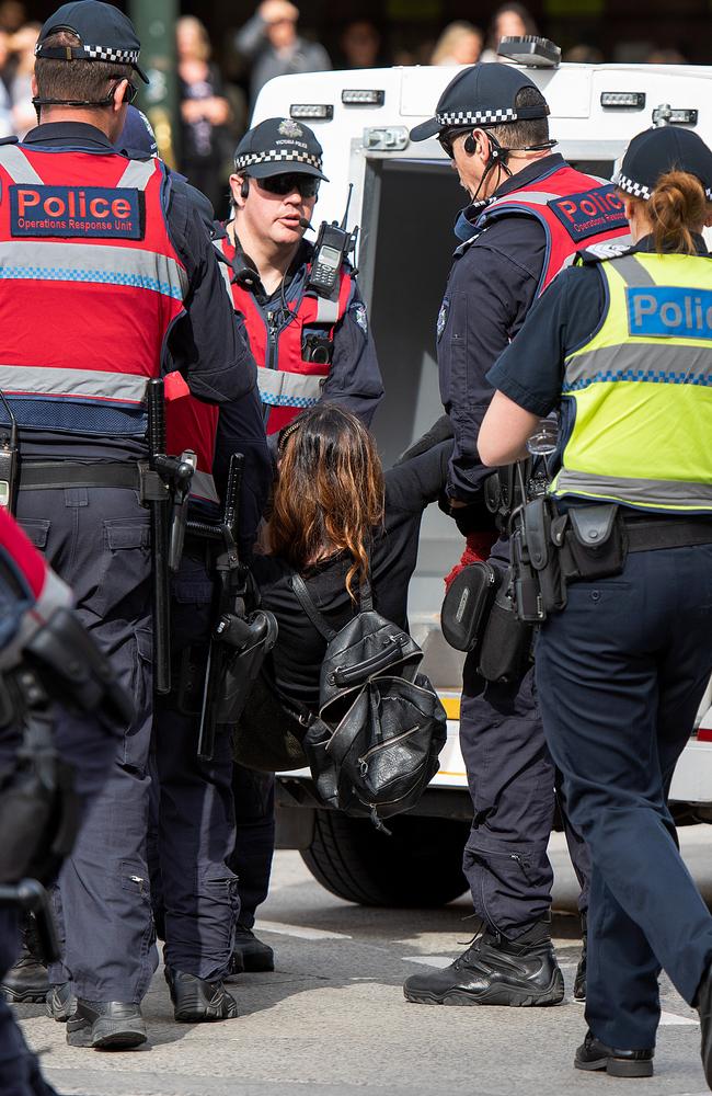 An animal rights protester who had blocked the intersections of Flinders and Swanston Street is removed by police, in Melbourne on Monday. Picture: AAP Image/Ellen Smith