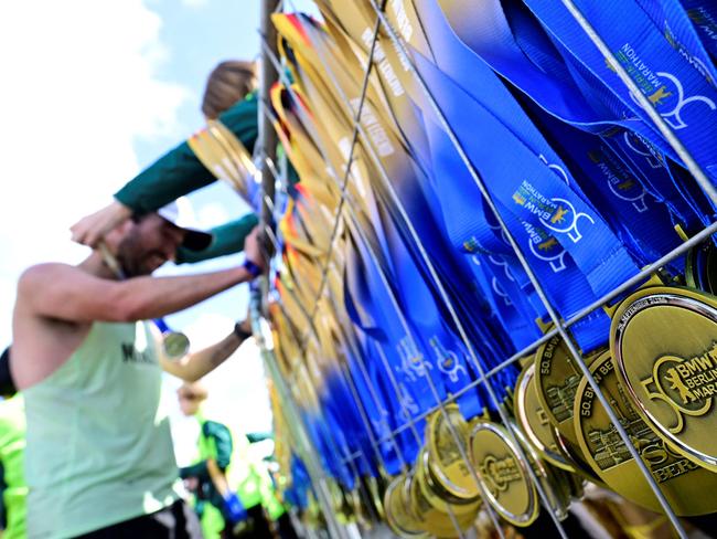 A runner is given a medal after finishing the 50th edition of the Berlin Marathon in Berlin, Germany on September 29, 2024. (Photo by John MACDOUGALL / AFP)