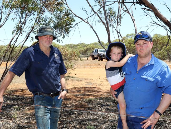 Darren Smith and Ash Jackson with his young son Tim pictured on the boundary of Ash's farm at Patchewollock and Wyperfield National Park. Picture: Glenn Milne