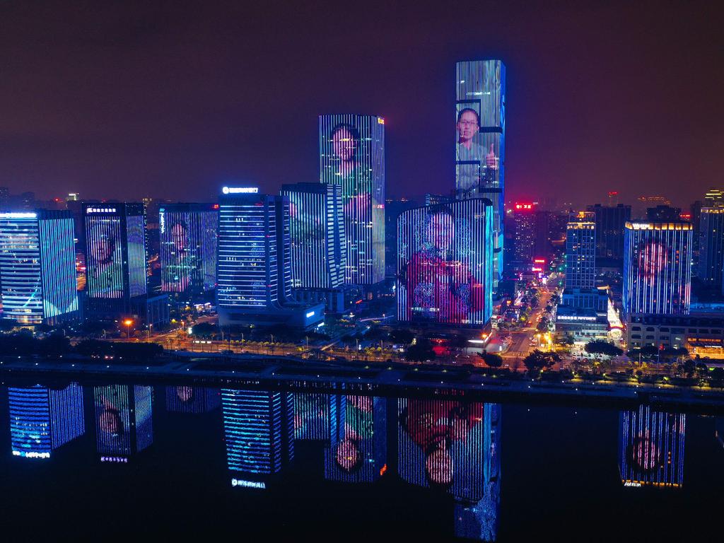 Health workers from Fujian who were sent to Wuhan to help with the recovery effort from the COVID-19 outbreak are projected onto buildings as a gesture of thanks. Picture: STR/AFP