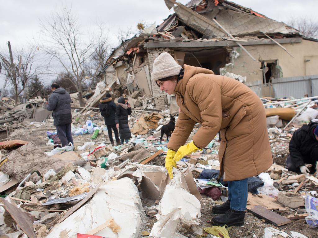 Neighbours and relatives help remove the rubble of a house destroyed with shelling in Markhalivka, Ukraine. Picture: Getty Images