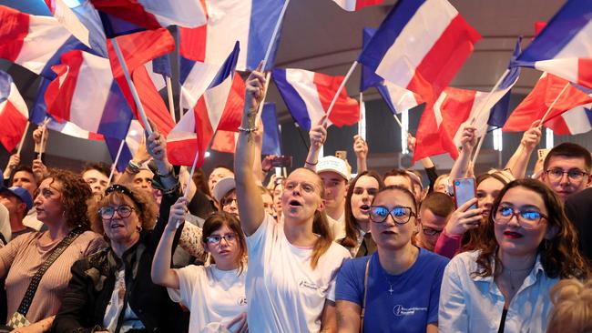 Supporters wave the national flag of France during a campaign meeting of France's far-right Rassemblement National (National Rally). Picture: AFP