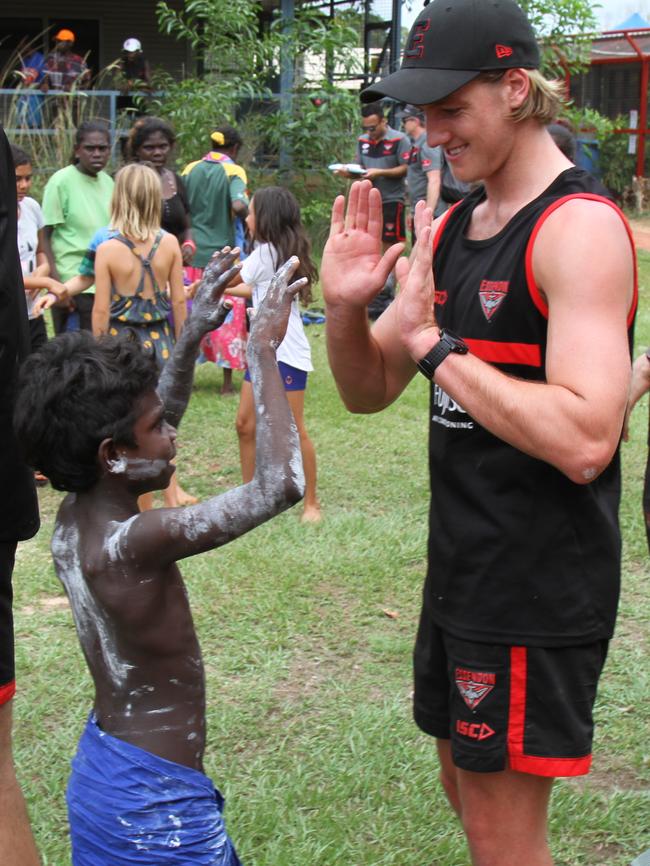 Darcy Parish high fives a student at Maningrida. Picture: NATALIE MacGREGOR