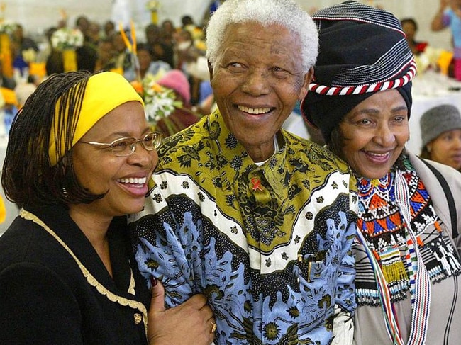 Former South African President Nelson Mandela celebrates his 86th birthday with his wife Graca Machel (L) and ex-wife Winnie Madikizela Mandela (R) in 2004. Picture: AFP