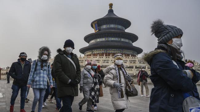 Visitors wear protective masks as they tour the grounds of the Temple of Heaven during Spring Festival in January. Picture: Getty Images