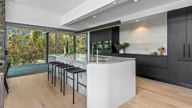 The kitchen featuring two dishwashers, marble bench top and a butlers pantry.