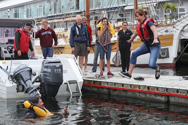 Julie Gathercole jumps into the water with fishing tv personality Andrew Hart filming from the water at a demonstration from Marine And Safety Tasmania about dodgy life jackets. Picture: LUKE BOWDEN