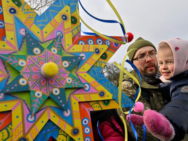 Ukrainian serviceman holds his daughter as they take part in Christmas celebrations near Kyiv on December 25. Picture: AFP